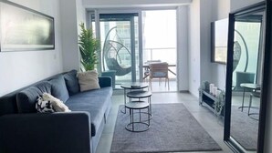 Een moderne woonkamer met een bank, een salontafel en een hangstoel.