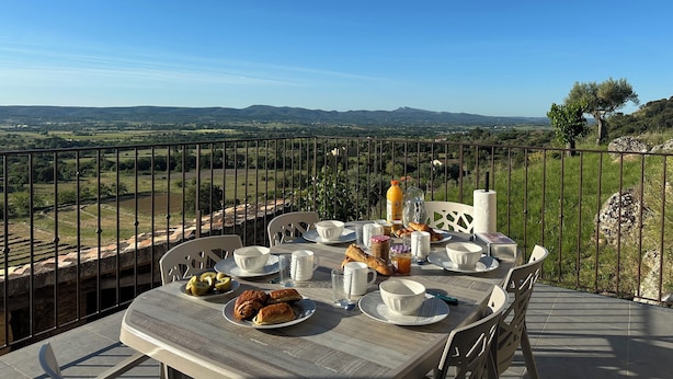 A table set for breakfast with a scenic view of hills and a clear sky. - Gîte « Les Oliviers » Dans Mas Typiquement Ardéchois - 6 Personnes (Saint-Sauveur-de-Cruzières)