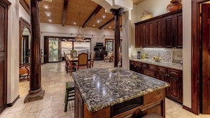 A spacious kitchen with a large island, wooden cabinets, and a high ceiling with exposed beams. - Papagayo Ocean View Luxury Villa (Carrillo Guanacaste)