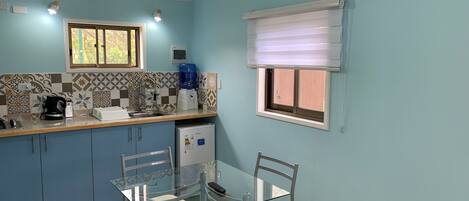 Een koelkast, een broodrooster, kookgerei, borden en bestek