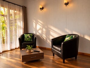 A room with two leather armchairs, a wooden coffee table, and a potted plant. - Comfortable and equipped cabin (Isla de Pascua)