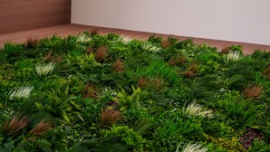 A modern interior with a geometric design, a wooden panel wall, and a lush green plant installation at the bottom. - Welcomely - Seamphony Deluxe Room (Olbia)