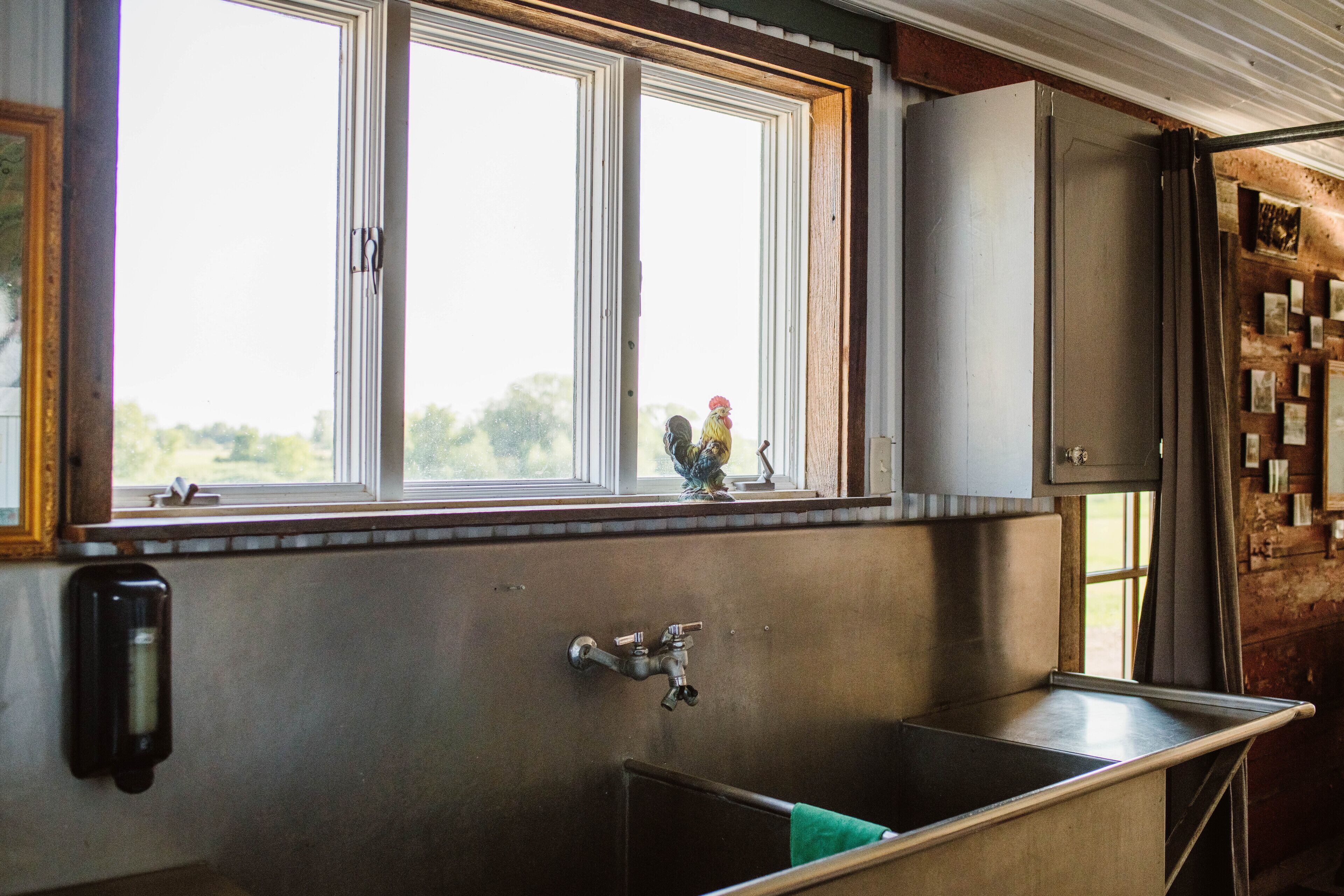 A kitchen with a large window, a sink, and a faucet.