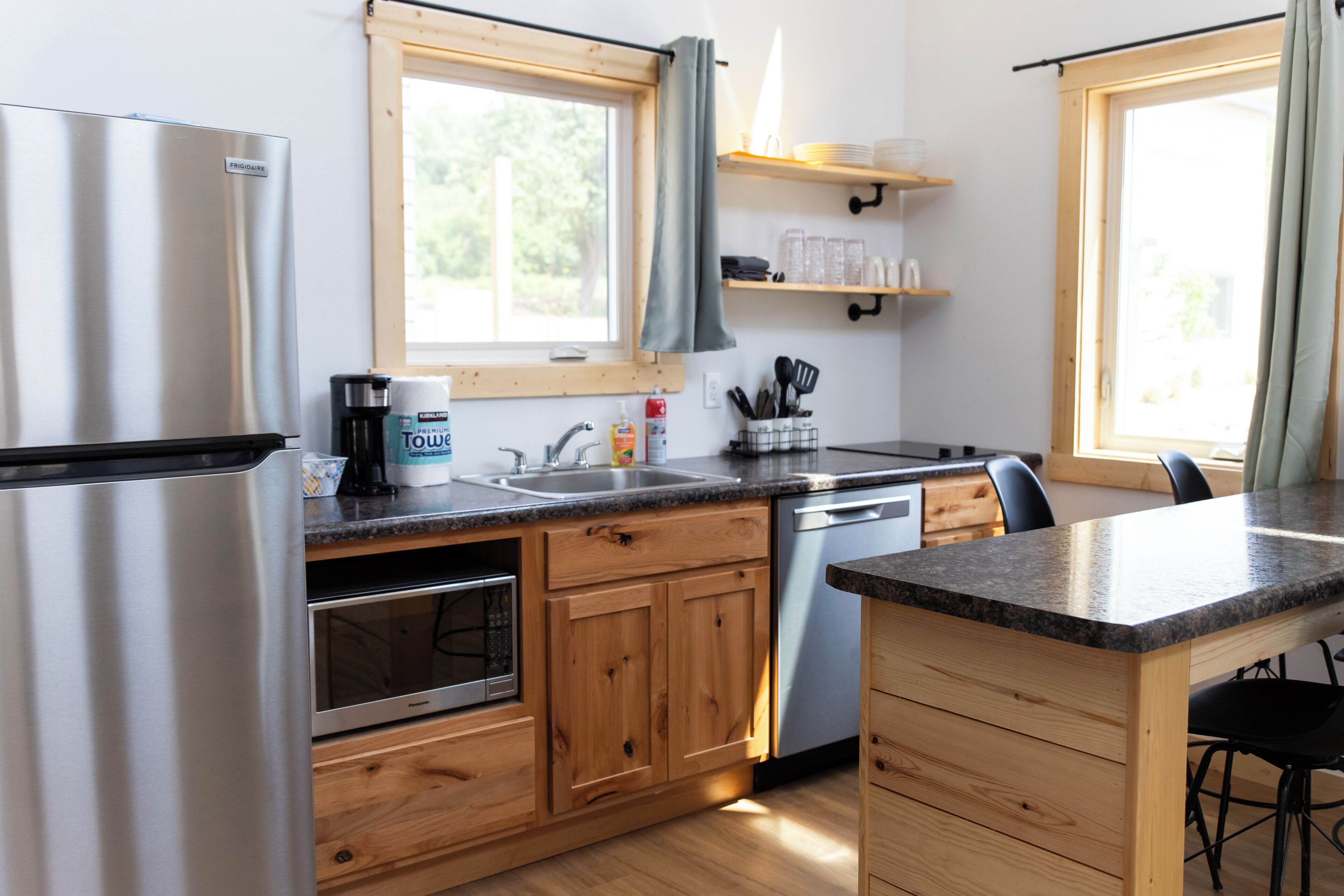 A modern kitchen with wooden cabinets, stainless steel appliances, and a granite countertop.