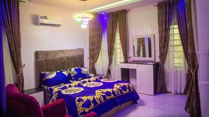 A bedroom with a bed, a desk, and an air conditioning unit. - RichVilla Apartments & Hotels (Lagos)
