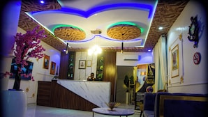 A hotel lobby with a reception desk, seating area, and decorative ceiling. - RichVilla Apartments & Hotels (Lagos)