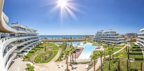 A modern hotel with a central swimming pool, multiple balconies, and a view of the ocean. - Choco | Pool - Frontline Beach - plunge pool (Torremolinos)