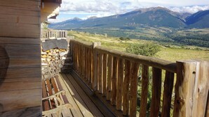 A wooden balcony with a stone wall and a view of a mountainous landscape. - Chalet les Petits Loups (Font-Romeu-Odeillo-Via)
