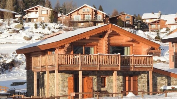 A wooden chalet with a balcony, surrounded by snow-covered hills. - Chalet les Petits Loups (Font-Romeu-Odeillo-Via)