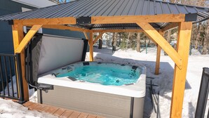 A hot tub under a wooden gazebo with a metal roof, surrounded by snow. - Big Yard Hot Tub Fire Pit Trail Pictured Rocks (Munising)