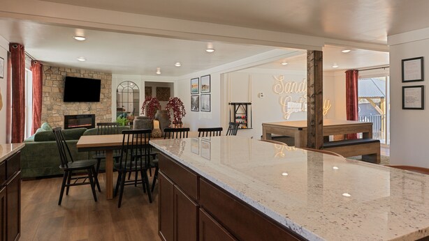 A spacious kitchen with a large island, dining area, and a stone accent wall. - Big Yard Hot Tub Fire Pit Trail Pictured Rocks (Munising)