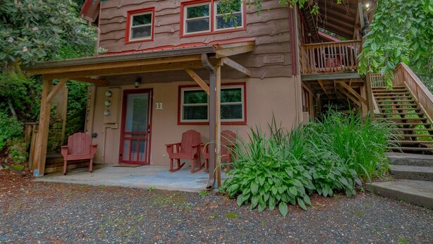 A log cabin with a porch, a staircase, and a sign indicating it is a chalet.