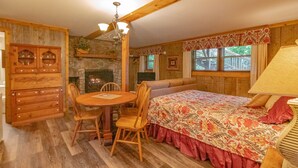 A cozy room with a fireplace, wooden furniture, and a bed with floral bedding.
