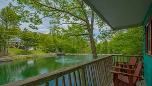 A wooden deck with a view of a pond and surrounding greenery. - Cozy Lakeside Cabin #15 - Sleeps 6 - Full kitchen + fireplace - between Boone & Blowing Rock NC (Blowing Rock)