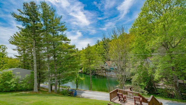 A lakeside property with a wooden deck, a small dock, and a house in the background. - Cozy Cabin #38 - Sleeps 6 - Full kitchen + fireplace - between Boone & Blowing Rock NC (Blowing Rock)