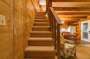 Stairs lead to a dining area with a table and seating for communal meals.