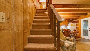 Eine Holztreppe führt zu einem Essbereich mit Tisch und Stühlen.