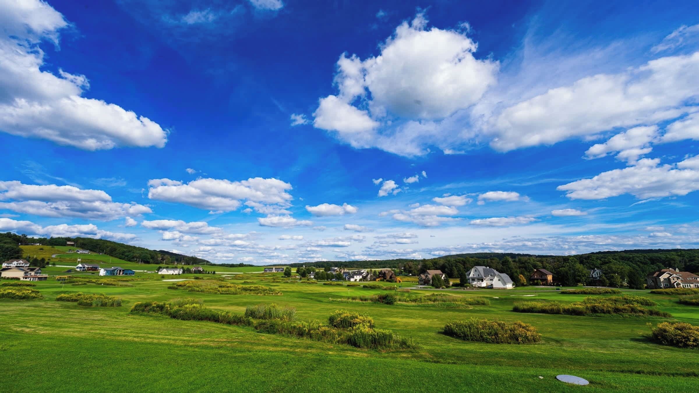 Un campo de golf con casas al fondo.