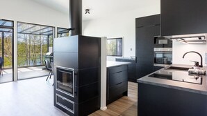 A modern kitchen with a built-in oven, a large window, and a view of the outdoors. - Villa Eslahti - Seafront/Jacuzzi (Porvoo)