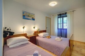 A hotel room with two beds, a painting, a panda plush toy, and a window with curtains. - Villa Katherine with Pool and Game Room (Žminj)