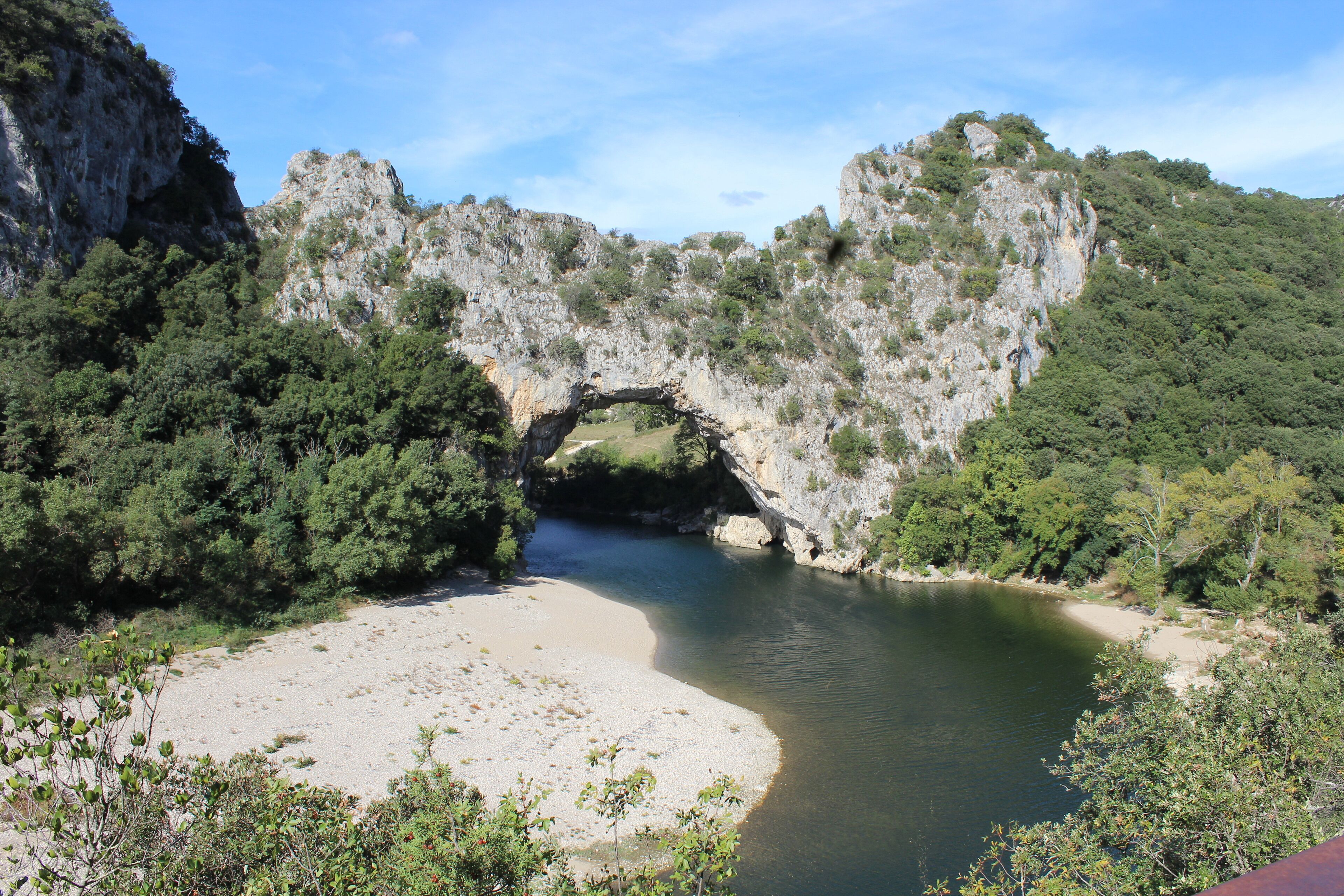 A natural rock formation with a river flowing through it.