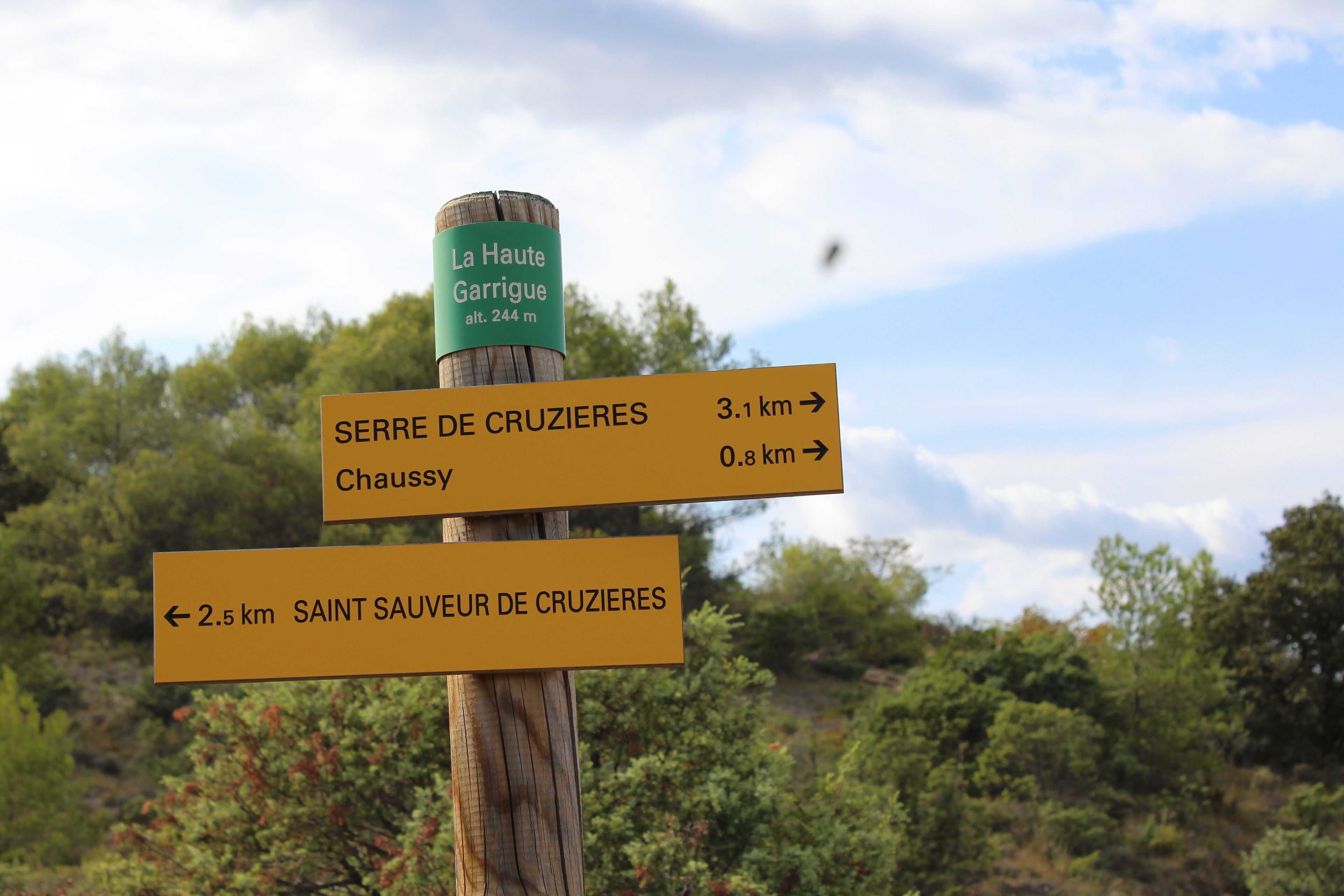 Un panneau indicateur directionnel, doté de plusieurs flèches pointant vers différentes destinations, notamment Serre de Cruzières, Chaussy et Saint-Sauveur-de-Cruzières, avec les distances indiquées en kilomètres.