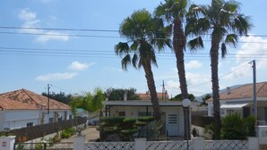 A residential area with houses, palm trees, and a gated entrance.