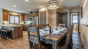 A spacious kitchen with wooden cabinets, a central island, and a dining area set for six.