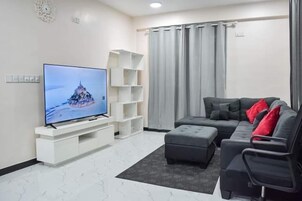 Habitación Deluxe, 1 cama doble, balcón, vistas parciales al mar | Zona de estar | Televisión de 32 pulgadas con canales digitales, Netflix
