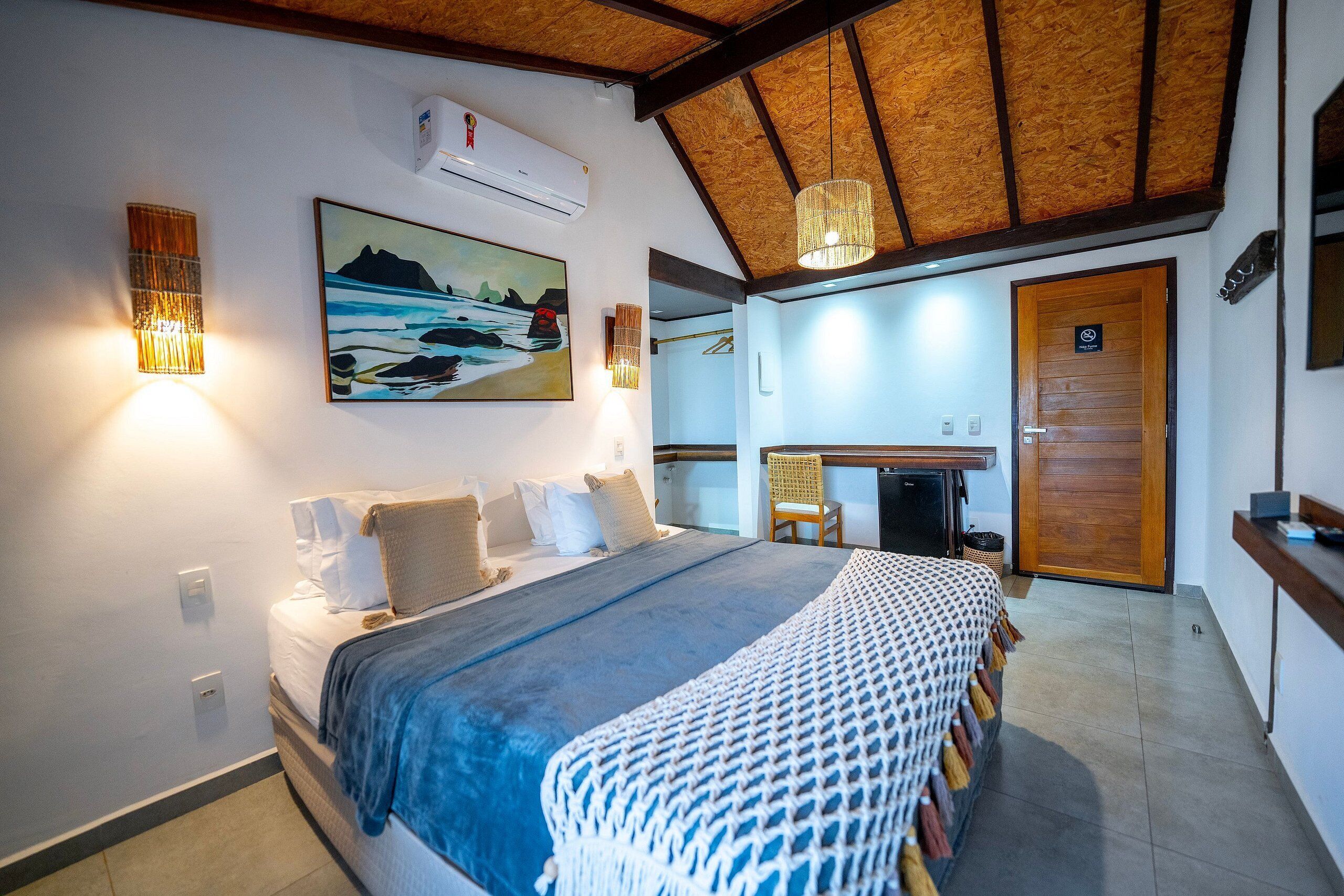 Une chambre à coucher avec un lit, des lampes de chevet, un tableau et un plafond en bois.