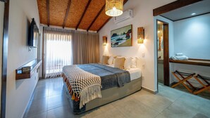 Ein Schlafzimmer mit einem Bett, einer Holzbalkendecke, einem Gemälde und einem Fernseher.