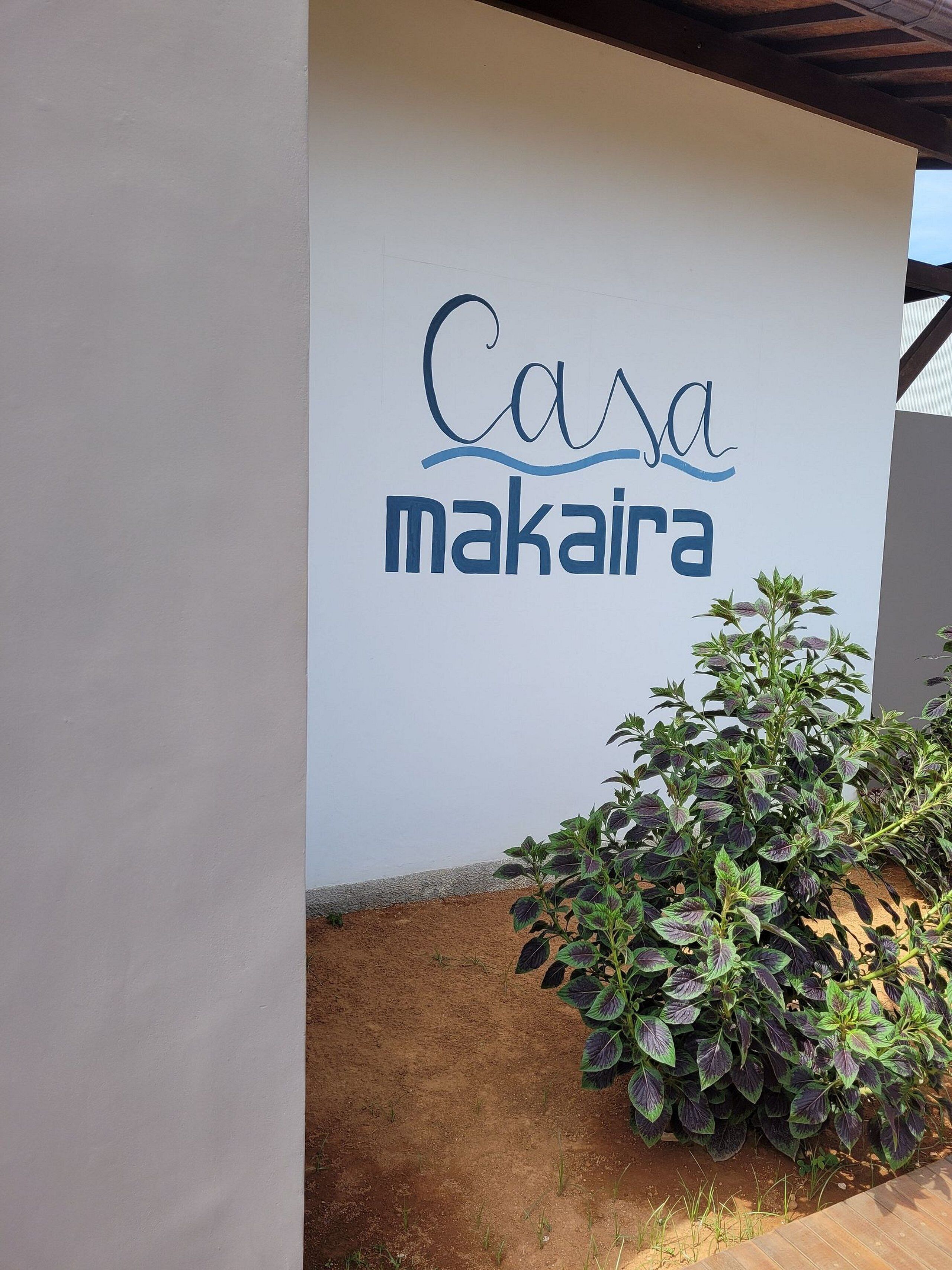 A building with a sign that reads 'Casa makaira' on a white wall.