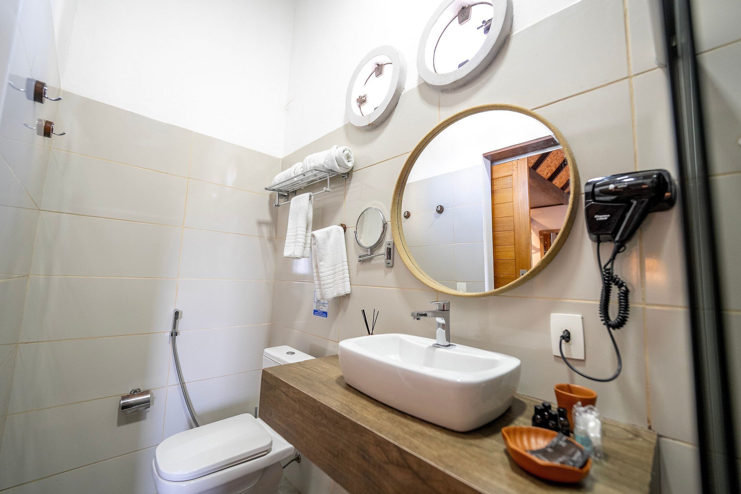 A bathroom with a white sink, a mirror, a towel rack, and a hairdryer.