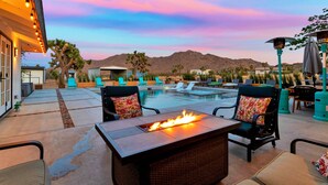 An outdoor pool area with lounge chairs, a fire feature, and a view of mountains. - Luxury 20-Acre Estate Pool, Spa, Game Room Sleeps 14 Near Joshua Tree NP (Joshua Tree)