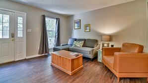 A living room with a sofa, armchair, coffee table, and a lamp. - 2 BR apt near Mtn to Sea Hiking Trail (Asheville)