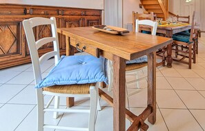 Enjoy meals in this cozy dining area with a wooden table and comfortable chairs.