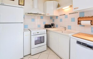 Efficient kitchen with a refrigerator, stove, sink, and dishwasher, plus ample storage and countertop space.