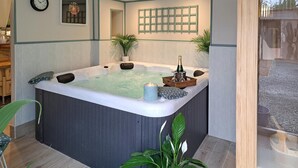 A hot tub with a candle, a bottle, and a basket. - Gorgeous home in Thierville (Thierville)