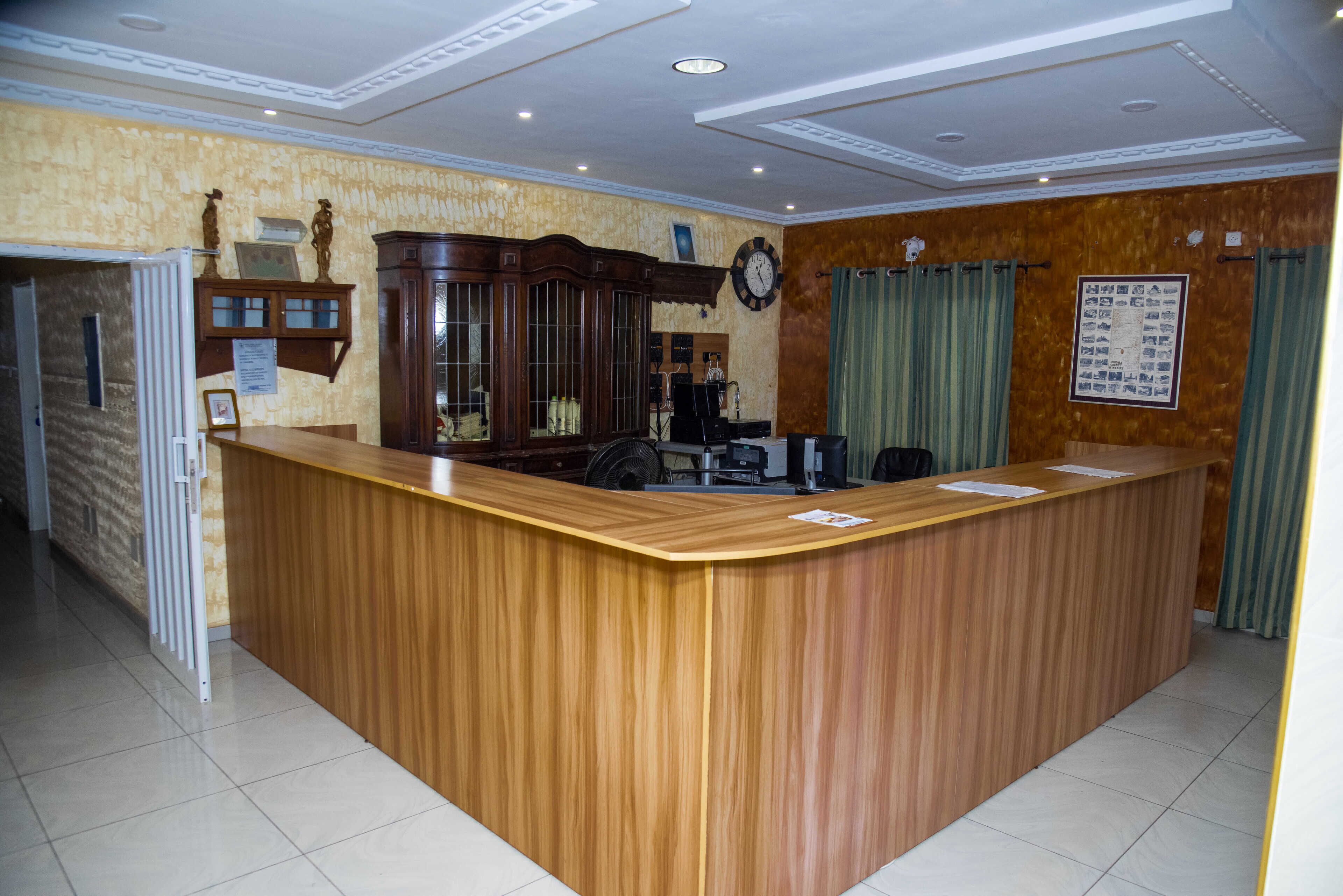 Una zona de recepción con mostrador de madera, un reloj y un tablón de anuncios.