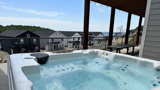 Ein Whirlpool mit Blick auf Häuser und ein Gewässer im Hintergrund.