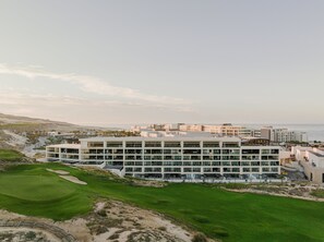Un hôtel moderne à plusieurs étages, doté d’un parcours de golf et offrant une vue sur la mer.