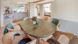 A dining area with a round table, wicker chairs, and a vase with flowers. - Awesome home in Harlösa with lake view (Harlösa)
