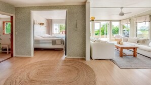 A spacious room with a bed, a sofa, and a dining area. There is a large window providing natural light and a view of the outdoors. - Awesome home in Harlösa with lake view (Harlösa)
