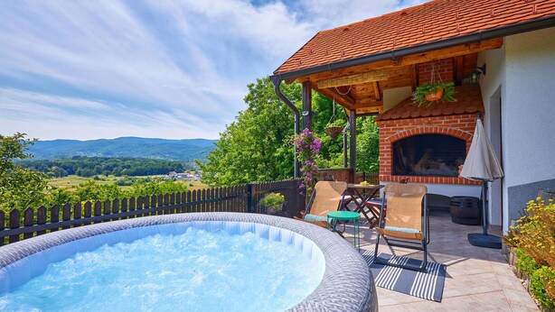 Ein Whirlpool, Sitzgelegenheiten im Freien, ein Kamin aus Ziegeln und eine schöne Aussicht.