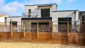 A modern two-story building with a balcony and a wooden fence. - Home with private pool (Saint-Jean-de-Monts)