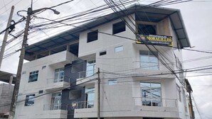 A multi-story building with a sign for 'HOSPEDALJE MORALILLOS' indicating a medical facility. - Hospedaje Moralillos (Yurimaguas)