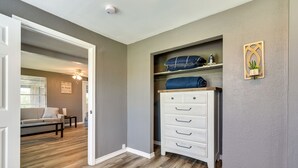 A hallway with a wooden floor, a white dresser with drawers, and a gray wall. - Deck & Fenced-In Yard: Texas Escape! (Freeport)