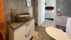 A modern bathroom with a large, round vessel sink, a mirror, and a toilet. - Cozy home in Tvååker with kitchen (Tvååker)