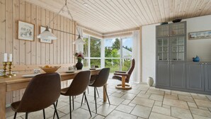 Een moderne keuken met houten lambrisering, een groot raam en een grijs kastje.