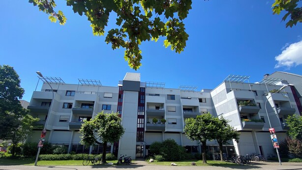 A multi-story residential building with balconies, a central entrance, and a bike parking area. - Seerhein apartment (Konstanz)
